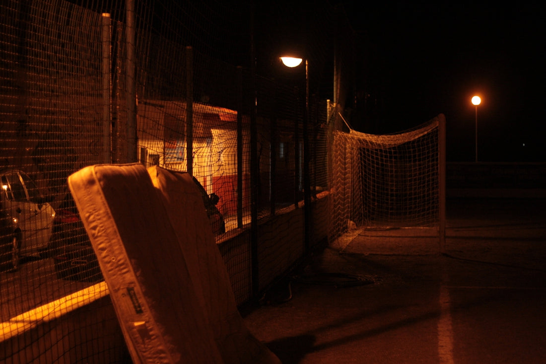 a chair sitting in front of a fence at night