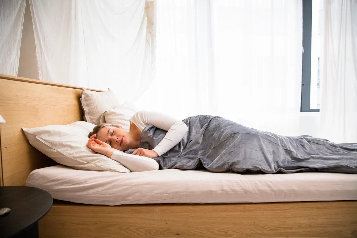 a man laying on a bed with a blanket on top of it