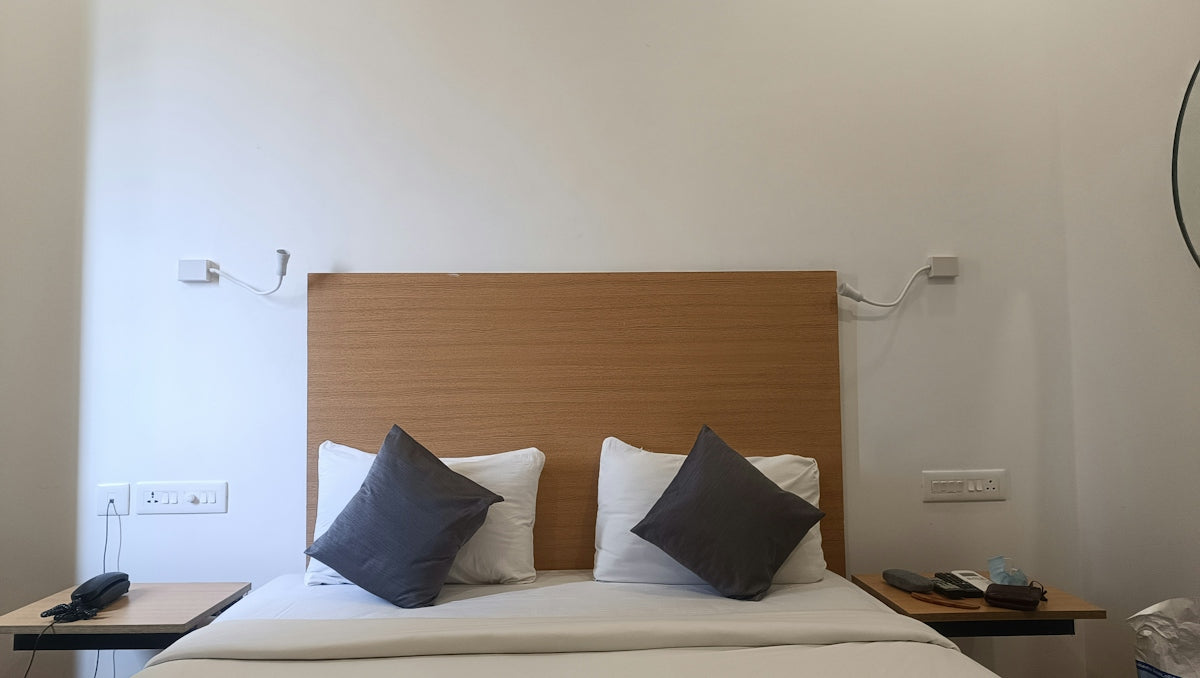 a bed with two pillows and a night stand