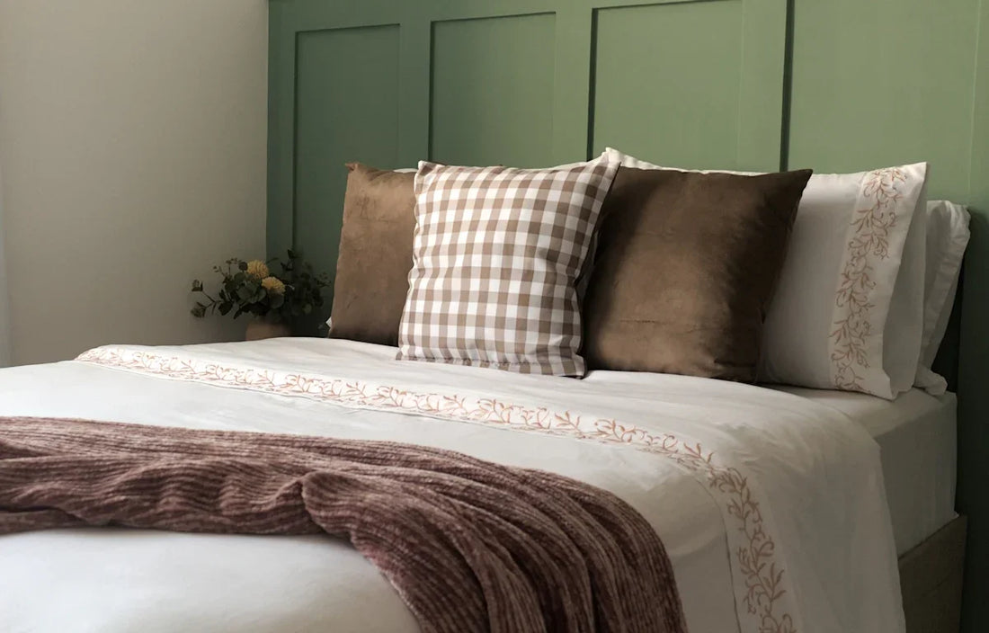 A bed with a blanket and pillows on top of it