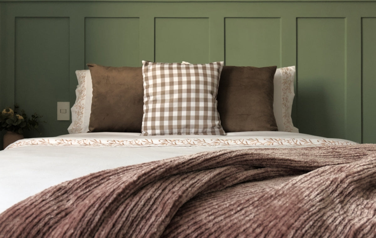 A bed with a blanket and pillows on top of it