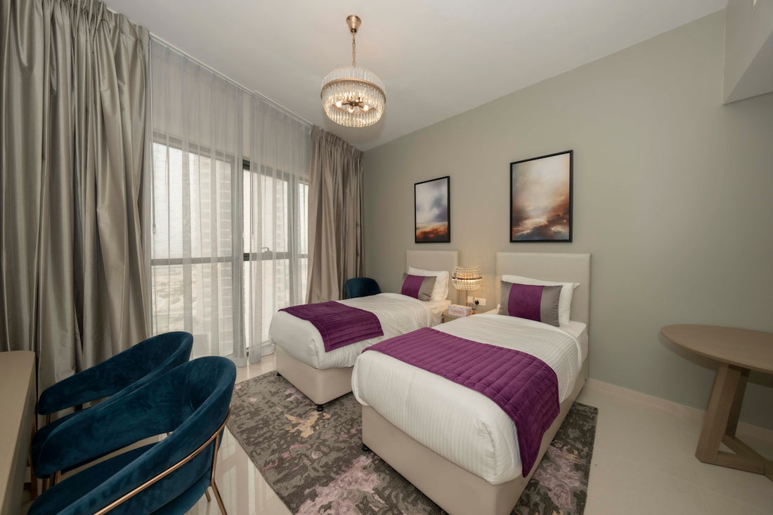 A bedroom with two beds and a desk