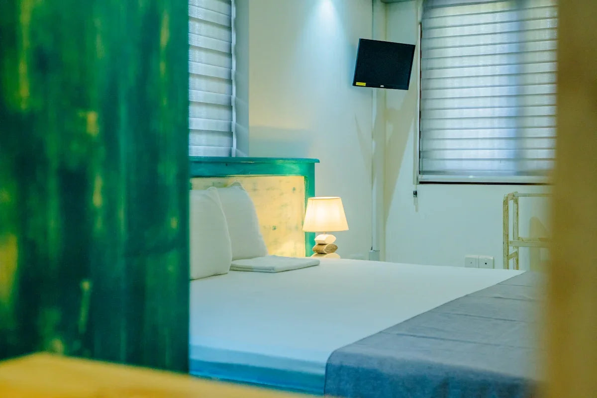 A comfortable bedroom with bed and lamp.