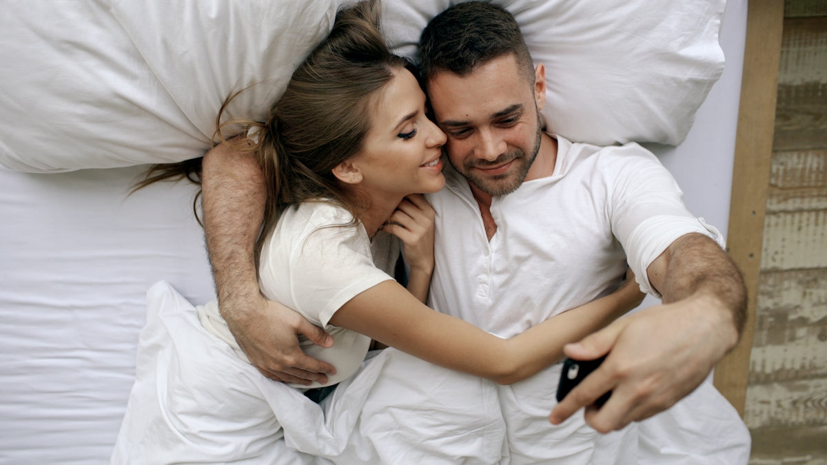 Couple taking a selfie in bed