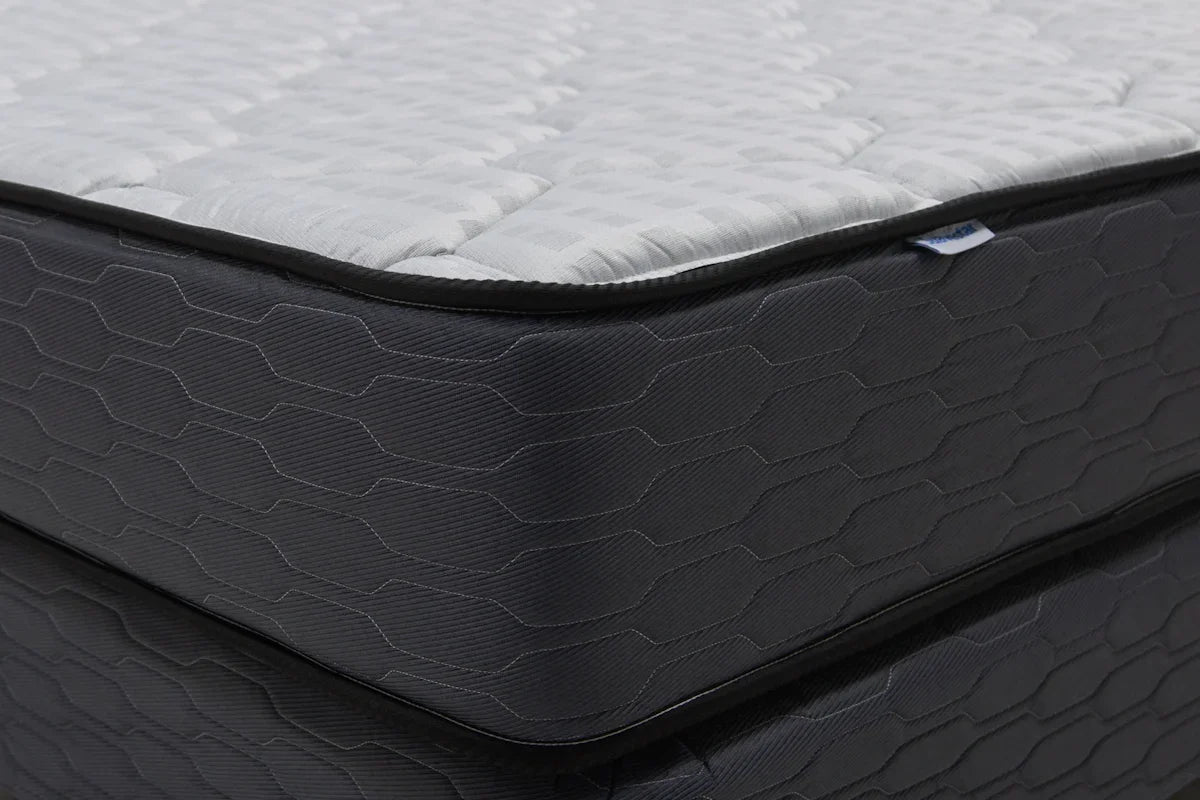 Close-up of a modern mattress with a dark patterned base.