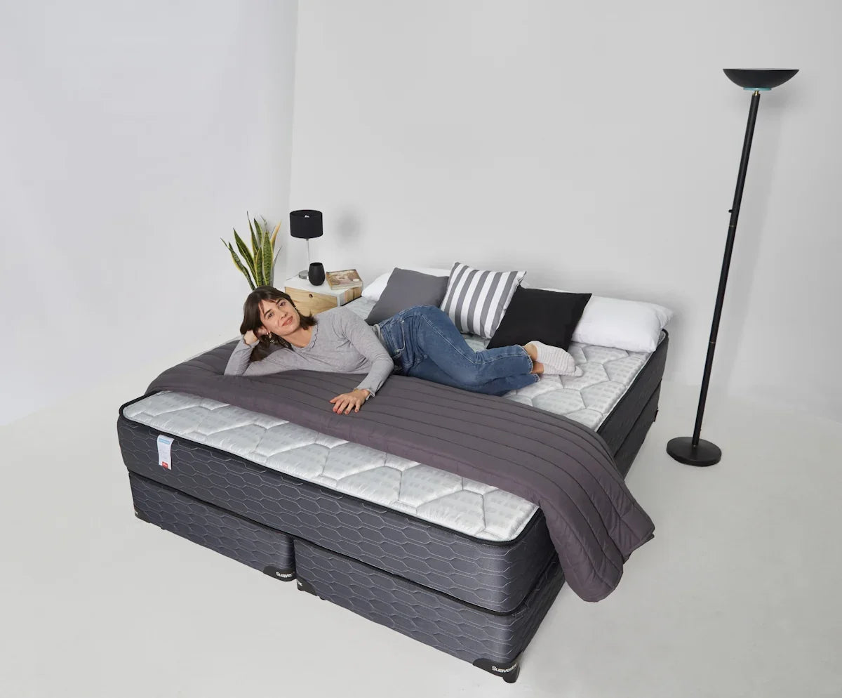 Woman relaxing on a large bed with pillows