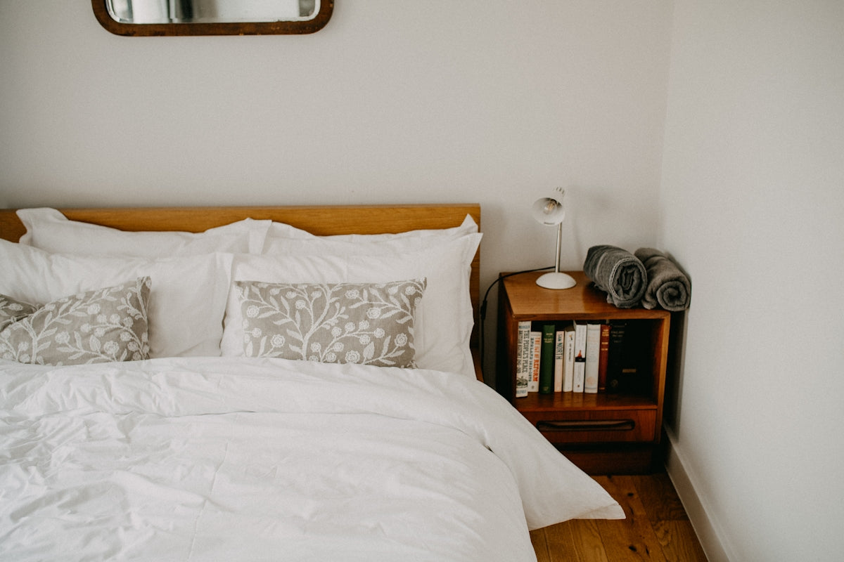 Cozy bedroom with a neatly made bed and bedside table.