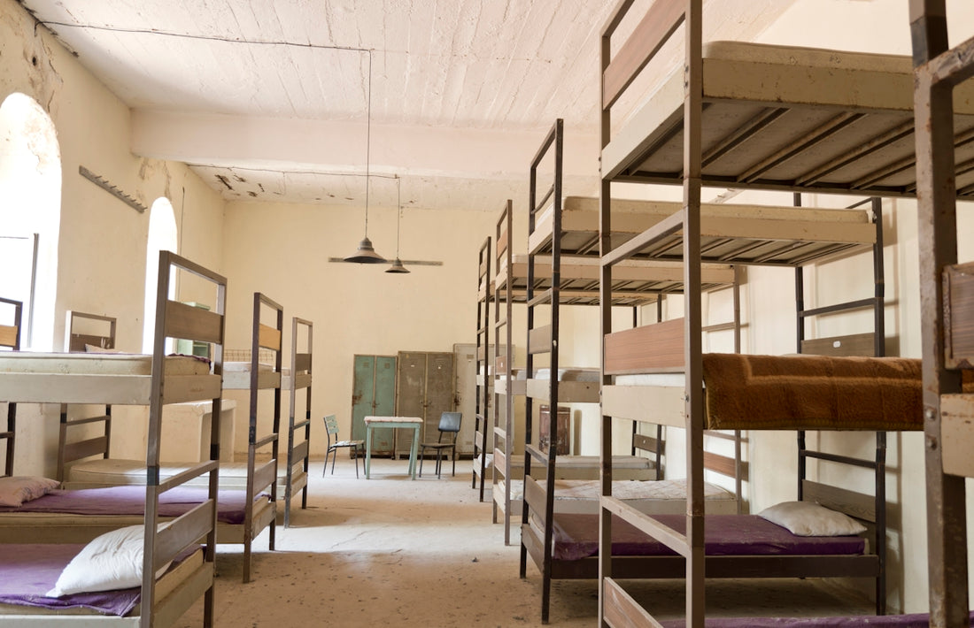 Bunk beds fill a dimly lit dormitory room.