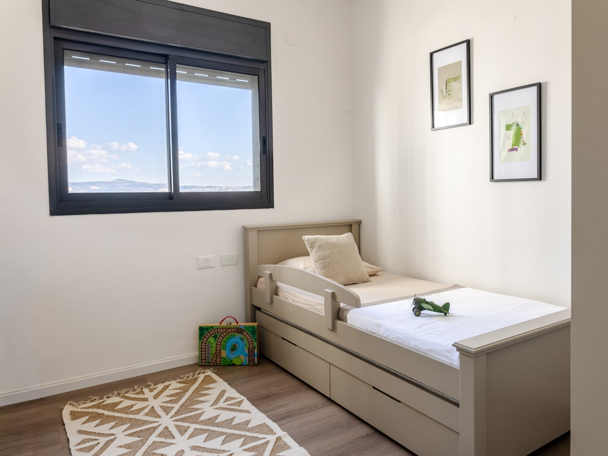 A child's bedroom with a twin bed and toys.