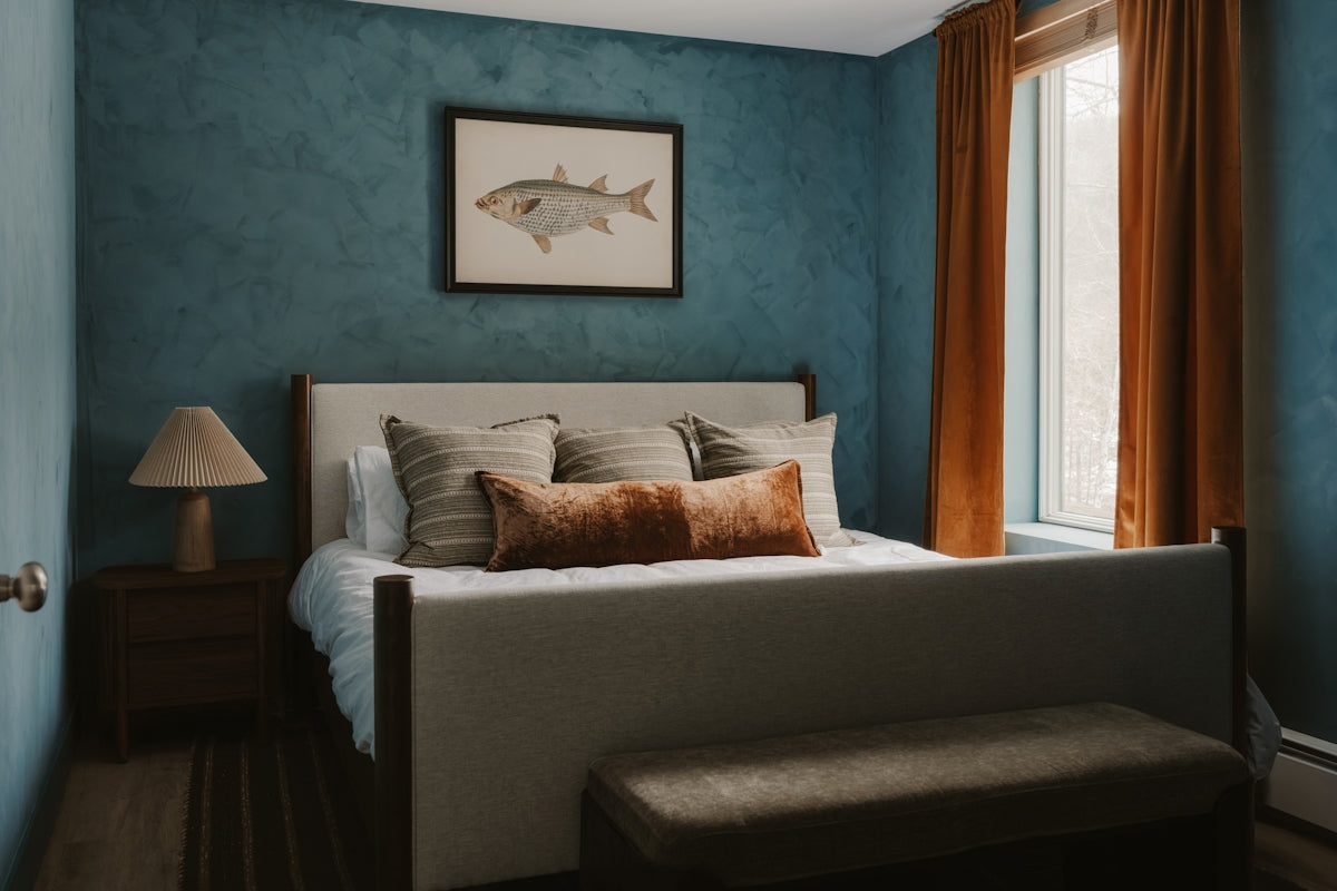 Bedroom with blue textured walls and a queen-sized bed.
