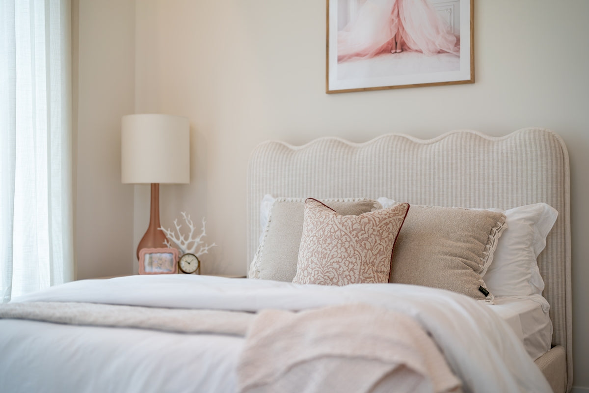 A cozy bedroom with a white bed and pink accents.