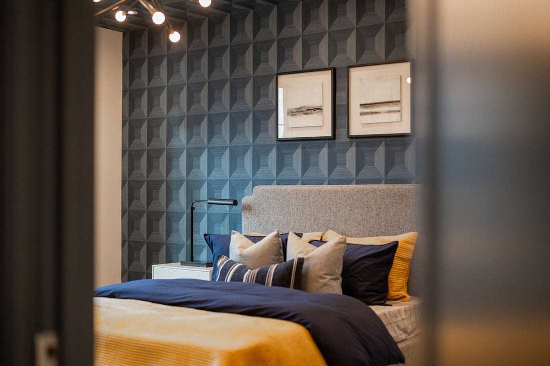 A modern bedroom with a textured blue wall and artwork.