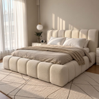 A modern cloud bed with a chunky, tufted upholstered frame in cream boucle fabric, styled with neutral beige bedding and a textured throw blanket in a bright, sunlit bedroom.