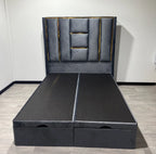 Front view of the Luxe Panel Ottoman Bed in grey upholstery with gold headboard detailing